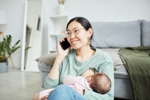 Happy mother breast feeding her baby infant